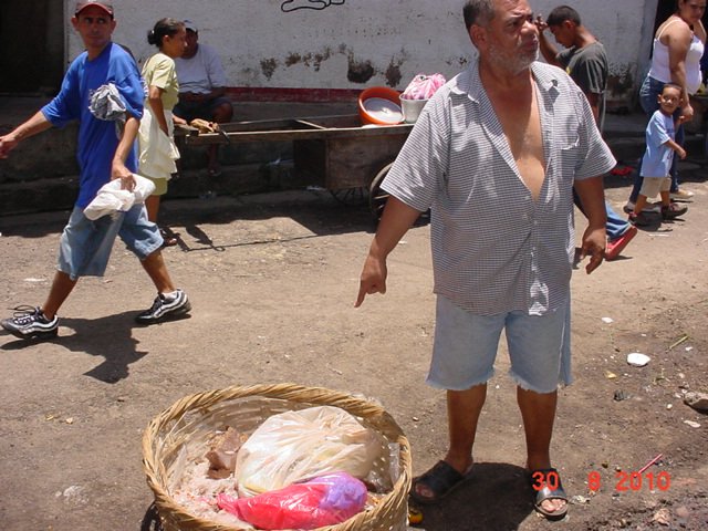 Don Jose Enrique Solorzano senala un canasto con restos de pollo podridos, al funcionario del Mercado